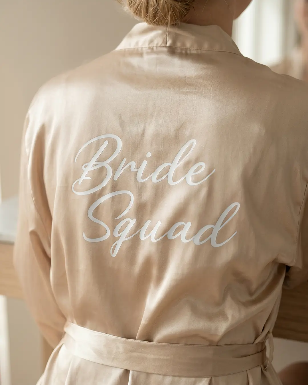 Cremefarvet morgenkåbe til brudepiger med teksten 'Bride Squad' på ryggen